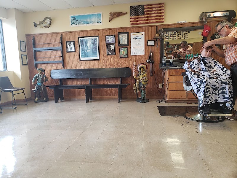 Interior of Pete's Barber Shop — American flag, wood paneling, classic barber chair, and waiting bench