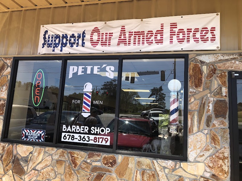 Pete's Barber Shop storefront in Dallas, Georgia — barber pole, Support Our Armed Forces banner, and stone facade on Dallas Acworth Highway