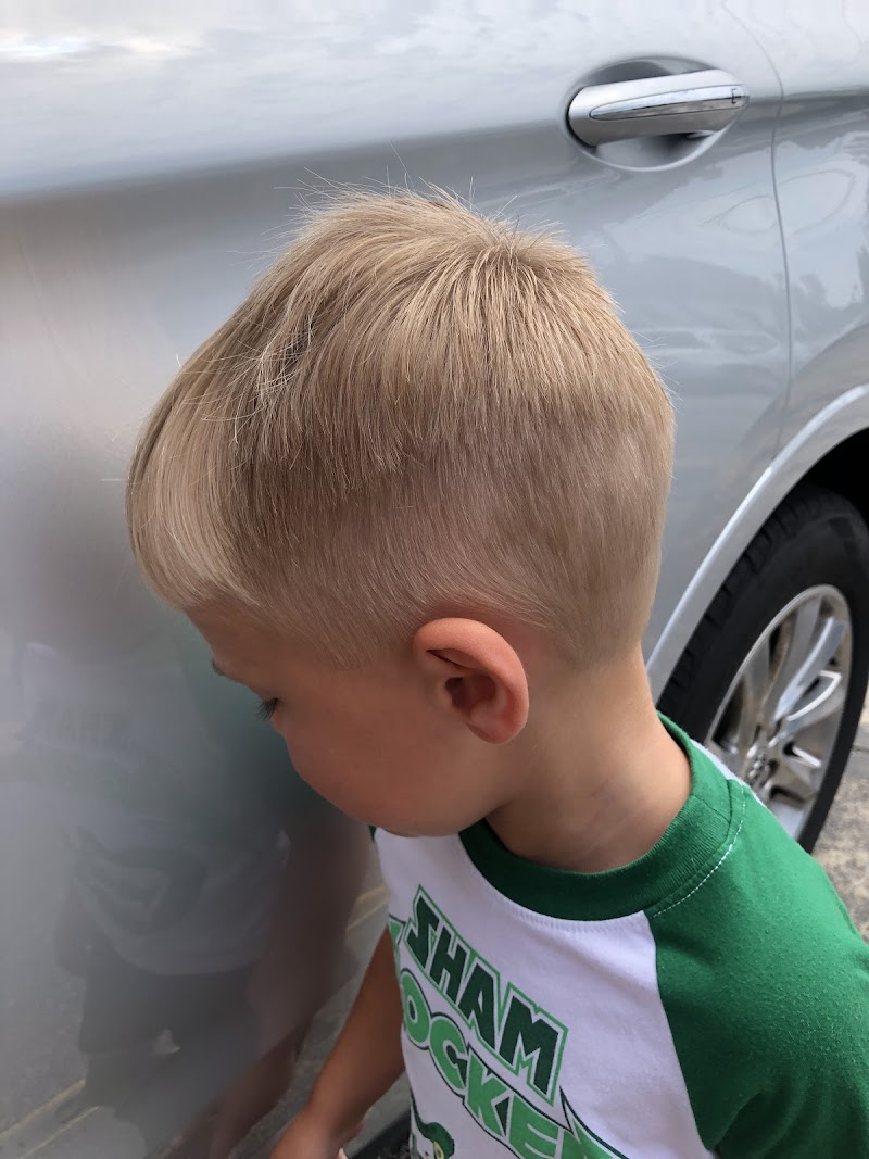 A young boy proudly showing off his fresh haircut